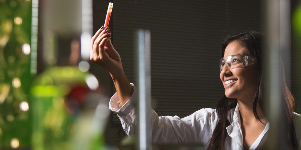 AllinAll employee looking at test tube (female)